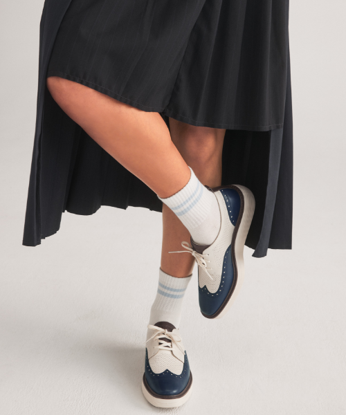 Woman standing wearing blue oxfords