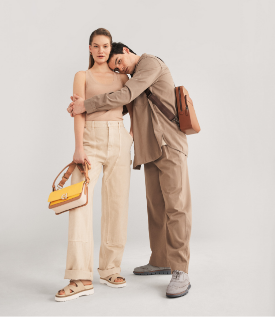 Man in tan suit laying down with feet up wearing sneakers