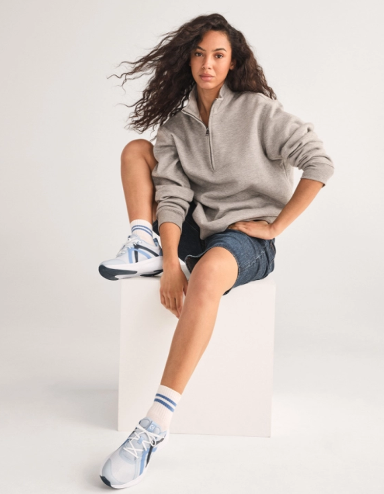 Man in tan suit laying down with feet up wearing sneakers